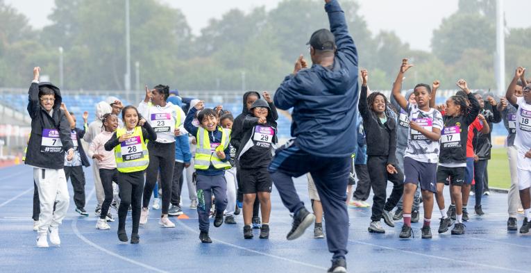 A group of children taking part in physical activity on an athletics track
