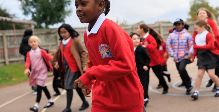 Pupils taking part in The Daily Mile in a school playground 