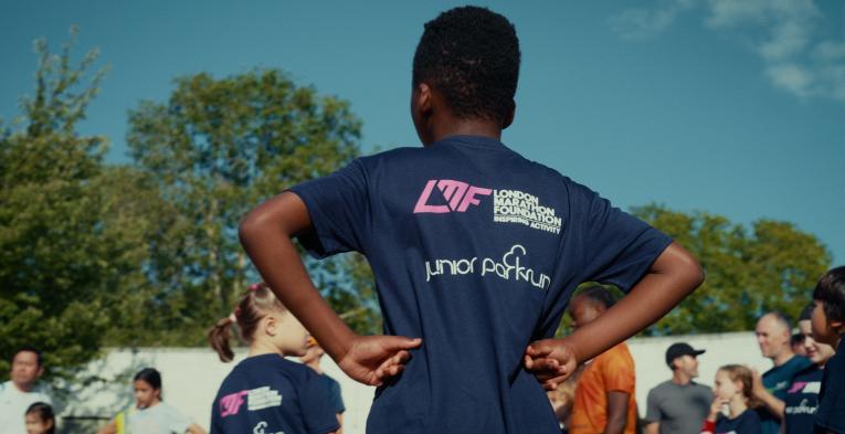 Child at junior parkrun wearing a t-shirt with junior parkrun and London Marathon Foundation logos
