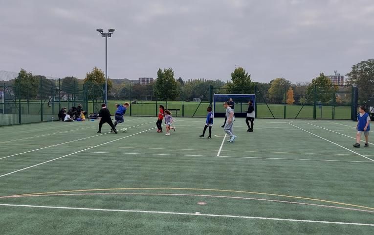 Mixed group of children playing football on a 3g pitch
