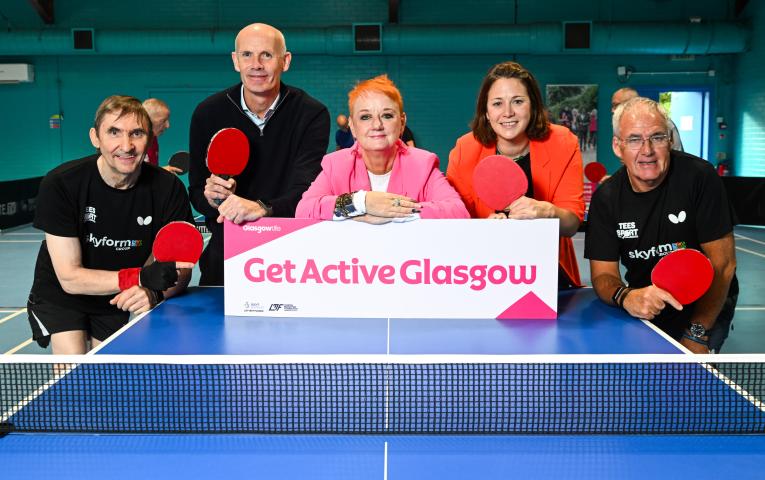 Get Active Glasgow funding partners gather behind a table tennis table