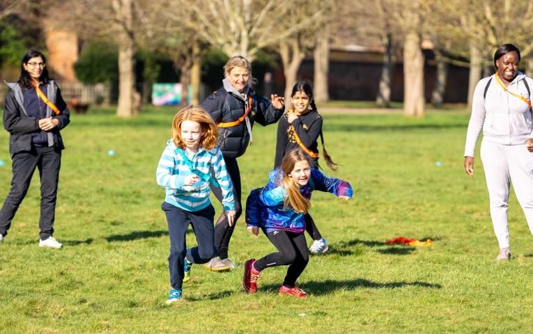 Two girls and their families playing in a park