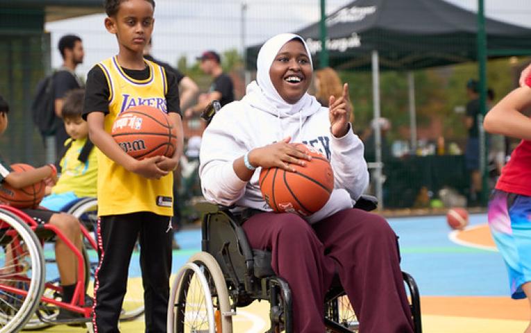Young wheelchair user holding a basketball 