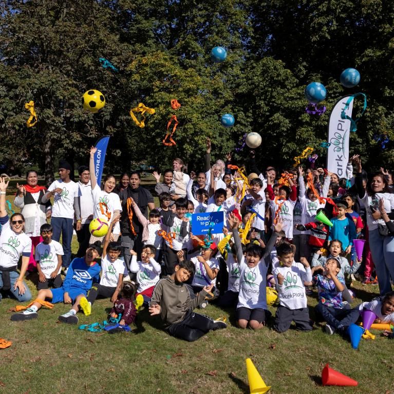 A group of families throwing balls in the air in a park. Photo credit Decathlon