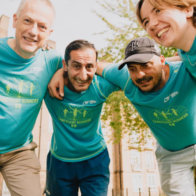 Sanctuary Runners smiling in a group huddle 