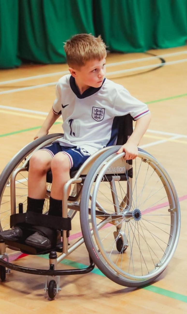 A child in a wheelchair playing wheelchair football