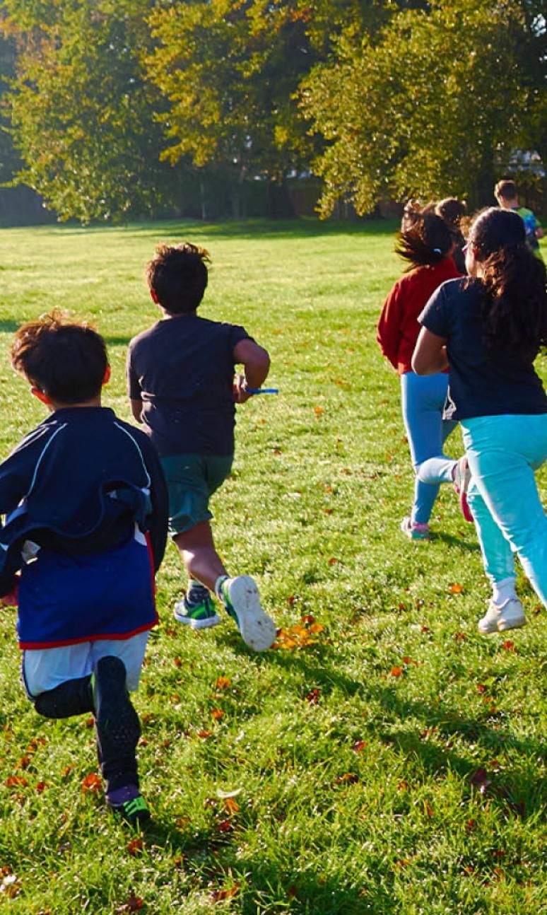 Children running into the sunshine during junior parkrun