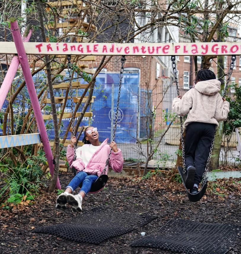 Girls playing on swings at Triangle Adventure Playground