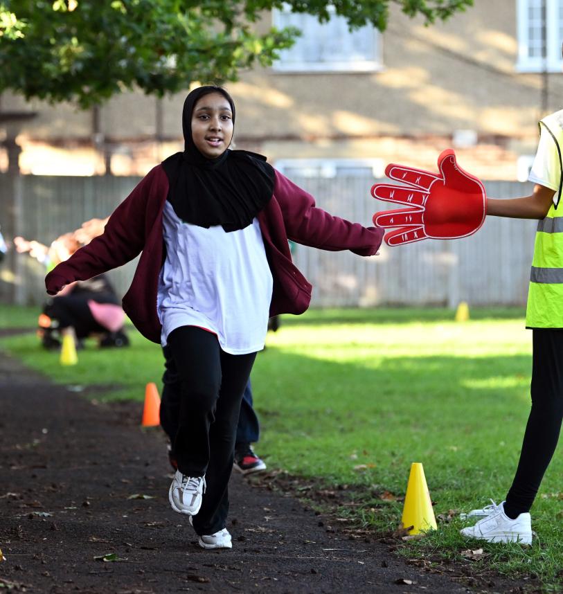 junior parkrunner high fives a volunteer during the event