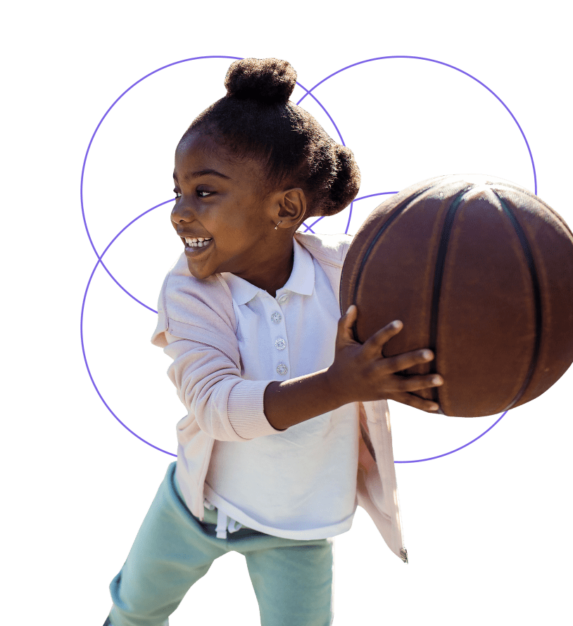 little girl smiling running with a basket ball in her hands